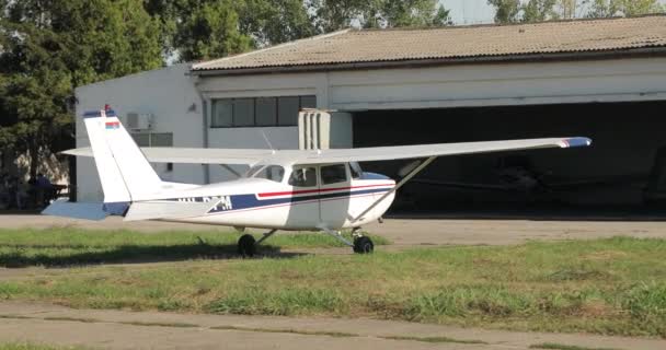 一架带有螺旋桨翼和驾驶舱的蓝色条纹的老白色飞机停在机库附近 贝尔格莱德塞尔维亚 — 图库视频影像