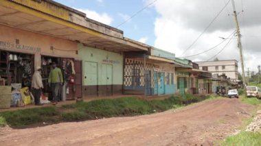 Kenya Köy Sokağı. Peoples Afrika kırsalında yaşıyor. Evler, dükkanlar ve arabalar sokakta duruyor..
