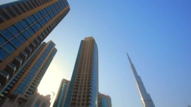 Emirliklerdeki Dubai 'nin şehir mimarisi. Gün batımında çölde yüksek binalar. Geleceğin şehrinin cam gökdelenleri var..