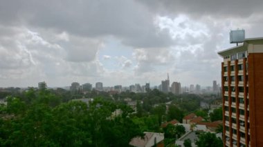 Kenya Nairobi 'de şehir manzarası. Bulutlu desenli gökyüzü, şehir merkezindeki Afrika başkentinde yüksek binalar, şehir merkezinde park ve manzara..