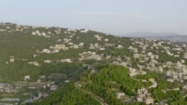 Köylü dağların havadan görünüşü. Dağlardaki ormanlarda dağ sıraları ve zirveleri olan evler var..