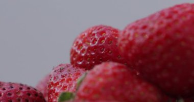 Macro shot çilek. Taze, organik, doğal, lezzetli ve kırmızı mevsimlik çilekler beyaz arka planda dönüyor..