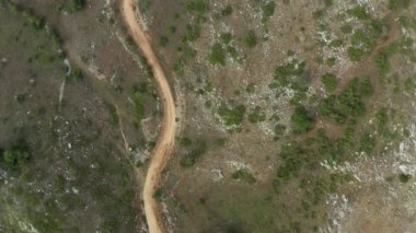 Makedonya hava sahasında. Dağlardaki yola paralel bir insansız hava aracı üzerinde güzel bir uçuş. Orada çalılar ve ağaçlar görebilirsiniz. Uçurumları, tepeleri ve manzarası olan dağlar..