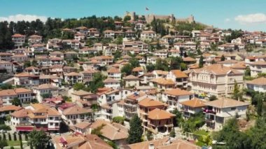 Hava manzaralı Ohri Makedonya. İnsansız hava aracı, tarihi merkezde kırmızı çatıları olan evlerin üzerinde uçuyor. Burada dağın arka planı bir kale ve güzel bir manzara. Yüksek kalite 4k görüntü