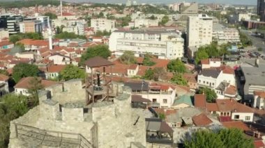 Dar caddelerin ve kırmızı çatılı evlerin bulunduğu tarihi merkezde duran bir caminin insansız hava aracı videosu. Üsküp Makedonya 'nın havadan görünüşü. Yüksek kalite 4k görüntü