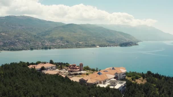 オフリド マケドニアの航空写真 山の上に赤い屋根の教会のドローンビデオと背景に湖や通り ボートや美しい風景とオフリッドの街 — ストック動画