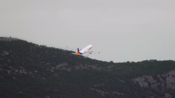 飞机在高山的背景下起飞 飞机在美丽的山顶上升向天空 — 图库视频影像