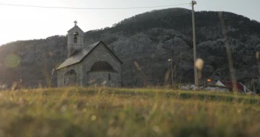 Dağlardaki kilise. Gün batımında dağlarda duran eski bir kiliseyi gösteren güzel bir video. Karadağ 'da 4 atış.