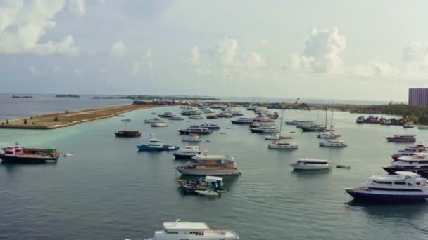 马尔代夫的空中景观 在印度洋一个小岛上的港口 无人驾驶飞机在挤满了船和船的上空飞行 岛上有蓝色的海水 城市的背景是高楼大厦 — 图库视频影像