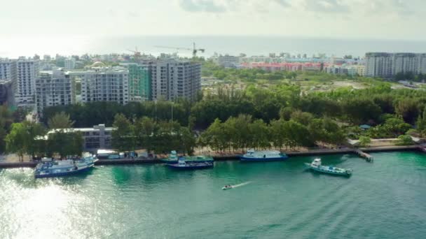 从空中向马尔代夫男性开枪 一个城市的无人机视频 该城市的房屋和街道矗立在印度洋海岸 港口停泊着船只和船只 高质量的4K镜头 — 图库视频影像