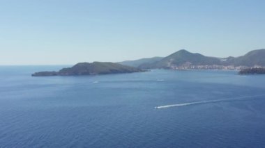 Adriyatik Denizi 'nin havadan görünüşü. Tekneler ve kayıklarla. İnsansız hava aracı videosu Budva, Karadağ. Dağlar ve tepelik şehir manzarası. Yüksek kalite 4k görüntü