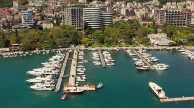 Budva Karadağ havacılık manzarası - Turkuaz Adriyatik Denizi kıyısında yaz tatili turistik beldesi. Küçük tekne ve yatlar için ortaçağ marinası. Yüksek kalite 4k görüntü