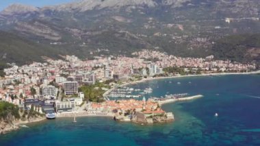 Budva Karadağ havadan vuruldu. Adriyatik kıyısındaki bir şehrin insansız hava aracı videosu dağlarla çevrili güzel bir manzarayla, eski ve yeni bir şehirle. Yüksek kalite 4k görüntü