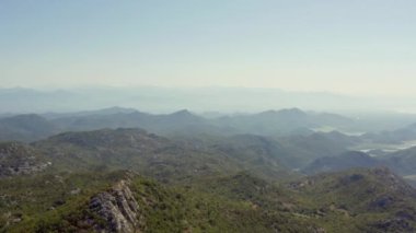 Karadağ 'ın havadan çekilmiş manzarası. Dağ sıralarının, tepelerin ve dağ tepelerinin drone görüntüsü. Arka planda nehir ve deniz var. Yüksek kalite 4k görüntü