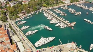 Budva Karadağ havacılık manzarası - Turkuaz Adriyatik Denizi kıyısında yaz tatili turistik beldesi. Küçük tekne ve yatlar için ortaçağ marinası. Yüksek kalite 4k görüntü