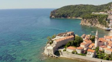 Budva Karadağ havadan vuruldu. Adriyatik kıyısındaki bir şehrin insansız hava aracı videosu dağlarla çevrili güzel bir manzarayla, eski ve yeni bir şehirle. Yüksek kalite 4k görüntü