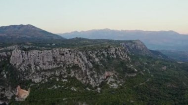 Karadağ havadan görünüyor. Güzel kızıl gökyüzü, uçurumlar ve manzaralı dağlarda gün batımının robot videosu. Yüksek kalite 4k görüntü