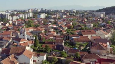 Karadağ 'ın başkenti Podgorica' yı hava saldırısı vurdu. Kırmızı kiremit çatılı evlerin olduğu tepeden insansız hava aracı görüntüsü. Yüksek kalite 4k görüntü