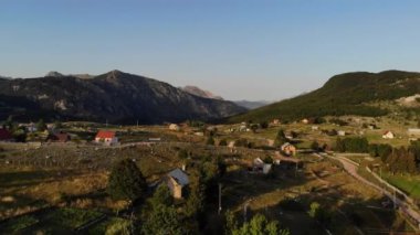 Karadağ 'daki Korita dağ köyünün hava görüntüsü. İnsansız hava aracından dağ tepeleri arasındaki evlere ve gün batımında dağ tepelerine bakın. Yüksek kalite 4k görüntü