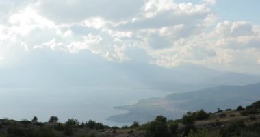 Makedonya Gölü ve Ohri kenti. Dağlarda bir gölün kıyısında duran şehrin manzarası. Dağların dibinde şehrin dokulu gökyüzünü görebileceğiniz bir yer..