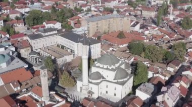 Şehir merkezinde eski evleri ve güzel manzarası olan bir minareyle tarihi caminin üzerinde uçan insansız hava aracı. Saraybosna Bosna-Hersek 'in hava manzarası.