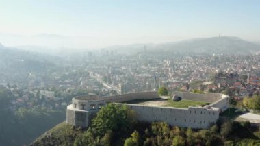 Saraybosna, Bosna-Hersek havadan görünüyor. Duvarları dağlarla çevrili antik bir kalenin insansız hava aracı videosu, tarihi bir şehir ve güzel bir manzara..