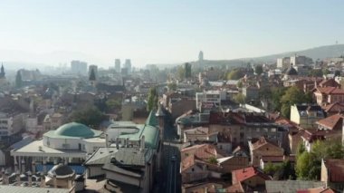 Eski ve yeni evlerin, şehir merkezindeki şehirlerin ve arka plandaki manzara dağlarının sokaklarını görebileceğiniz eski şehrin üzerinde uçan insansız hava aracı. Saraybosna Bosna-Hersek 'in hava manzarası.