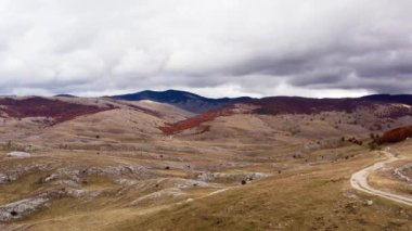 Sonbahar dağlarının havadan görünüşü. Güzel bir Aizazhny şehrindeki dağ sıralarında duran sarı ve altın yapraklarla kaplı ormanların üzerinde uçan dron. Dokulu gökyüzü ile sezonun videosu.