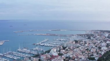 Marina dron 4K video. Aerial view of a port with boats and ships standing on the shores of the Mediterranean Sea in Palma on the island of Mallorca with historic buildings on the waterfront.