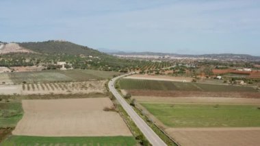 Dağlardaki tarım arazileri dron 4K videosu. Dağlara, zirvelere ve dokulu gökyüzüne tepeden bakan, ekili tarlalarla birlikte kırsal alanda büyüyen ekinlerin hava manzarası..