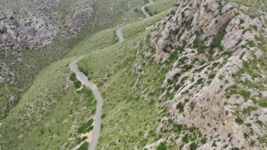 Serpentine road in the mountains dron 4K video. Aerial view of a landscape with a road that climbs the rocky slopes of mountain ranges with peaks. High quality 4k footage