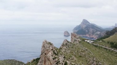 Okyanus dronunun yanındaki Rocky Dağları 4K videosu. Dalgaların çarptığı kayalık tepeler ve uçurumlarla dolu dağ sıralarının havadan görünüşü. Yüksek kalite 4k görüntü