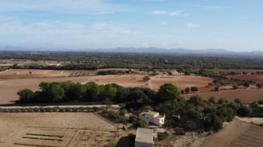 Dağlardaki tarım arazileri dron 4K videosu. Dağlara, zirvelere ve dokulu gökyüzüne tepeden bakan, ekili tarlalarla birlikte kırsal alanda büyüyen ekinlerin hava manzarası..