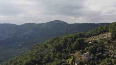 Dağ ormanlarındaki dron 4K videosunda yetişen zeytin tarlaları. Dağlarda kayalar ve kayalıklarla zeytin ve çam ağaçlarının havadan görünüşü. Yüksek kalite 4k görüntü