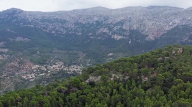 Dağ köyünün dron 4K videosu. Evleri ve caddeleri olan, dağlarla çevrili, ağaçlarla ve ormanlarla çevrili, manzaralı bir köy..