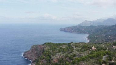 Akdeniz dron 4K videosundaki Rocky kıyı şeridi. İspanya 'nın Mallorca adasındaki deniz dalgalarına çarpan kayalıkları, tepeleri ve ağaçları gösteren hava manzarası..