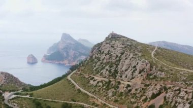 Okyanus dronunun yanındaki Rocky Dağları 4K videosu. Dalgaların çarptığı kayalık tepeler ve uçurumlarla dolu dağ sıralarının havadan görünüşü. Yüksek kalite 4k görüntü