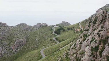 Serpentine road in the mountains dron 4K video. Aerial view of a landscape with a road that climbs the rocky slopes of mountain ranges with peaks. High quality 4k footage