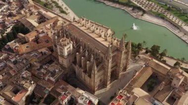 Historic cathedral dron 4K video. Aerial view of a gothic style church building that stands in the center of the city with streets and old houses in Palma on the island of Mallorca in Spain.