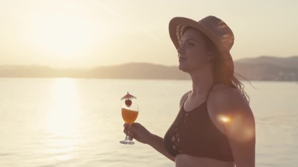 Повільне Відео Дівчиною Коктейлем Руках Йде Пляжі Заході Сонця Усміхнена — стокове відео