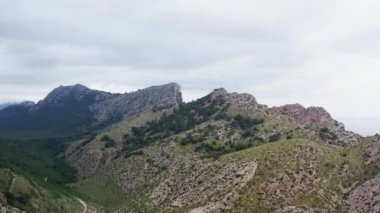 Okyanus dronu 4K videosunun Rocky sıradağları. Arka planda güzel bir manzara için dağların, tepelerin ve çalı ve çimlerle kaplı yamaçların havadan görünüşü. Yüksek kalite 4k görüntü