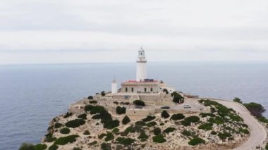 Lighthouse on the rock dron 4K video. Aerial view of the rock on which the waves of the Mediterranean Sea crash and at the top is a lighthouse building behind. High quality 4k footage