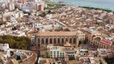 Architecture of a historic European city with a cathedral dron 4K video. Aerial view of the old church standing in the city center with houses, roofs, beautiful urban landscape.