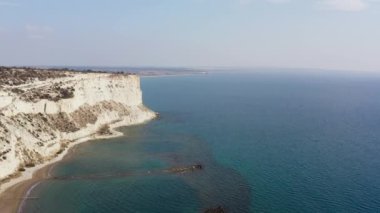 Adanın kıyı şeridinin insansız hava aracı videosu Akdeniz 'in dalgalarına çarpan kaya ve dağları gösteriyor. Kıbrıs Rum Kesimi 'nin deniz manzarası. Yüksek kalite 4k görüntü