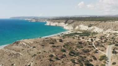 Akdeniz 'in dalgalarını kıran kayalıklara karşı denizin kayalık kıyı manzarası dağın arka planının olduğu güzel bir manzara. Peyzaj video arkaplanı.