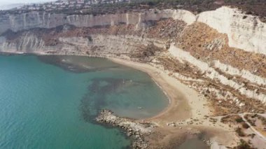 Aerial view of the lagoon with a beach standing at the bottom of the rocky mountains with cliffs and washed by the waves of the Mediterranean Sea in Europe. Beautiful background landscape video.