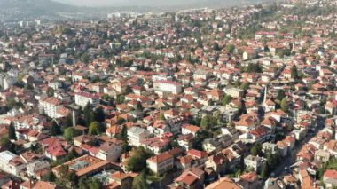 Drone flying over the old city where you can see the streets of old and new houses, downtown cities and landscape mountains in the background. Aerial view Sarajevo Bosnia and Herzegovina.
