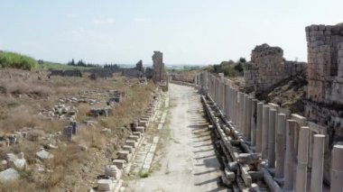 Eski, tarihi bir kentin sütunlarına sahip, evleri ve kalıntıları olan antik bir Yunan şehrinin sütunları olan bir caddenin insansız hava aracı videosu. Antalya Türkiye 'nin havadan görüşü. Yüksek kalite 4k görüntü