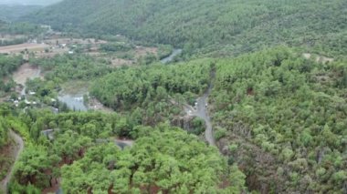 Drone video of a natural mountain landscape with mountains and ridges hints of growing forests with pine trees between which flows a mountain river .. Aerial view Antalya Turkey. High quality 4k 