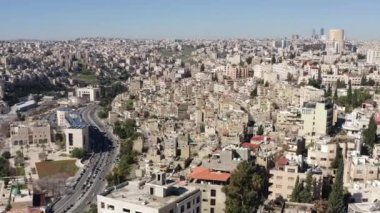 Şehrin yakınlardaki bir köydeki mimari ve şehir manzarasının insansız hava aracı videosu. Arap tarzı evler bir dağda duruyor, arabaların gittiği yol, şehrin hayatı ve caddeleri.. 